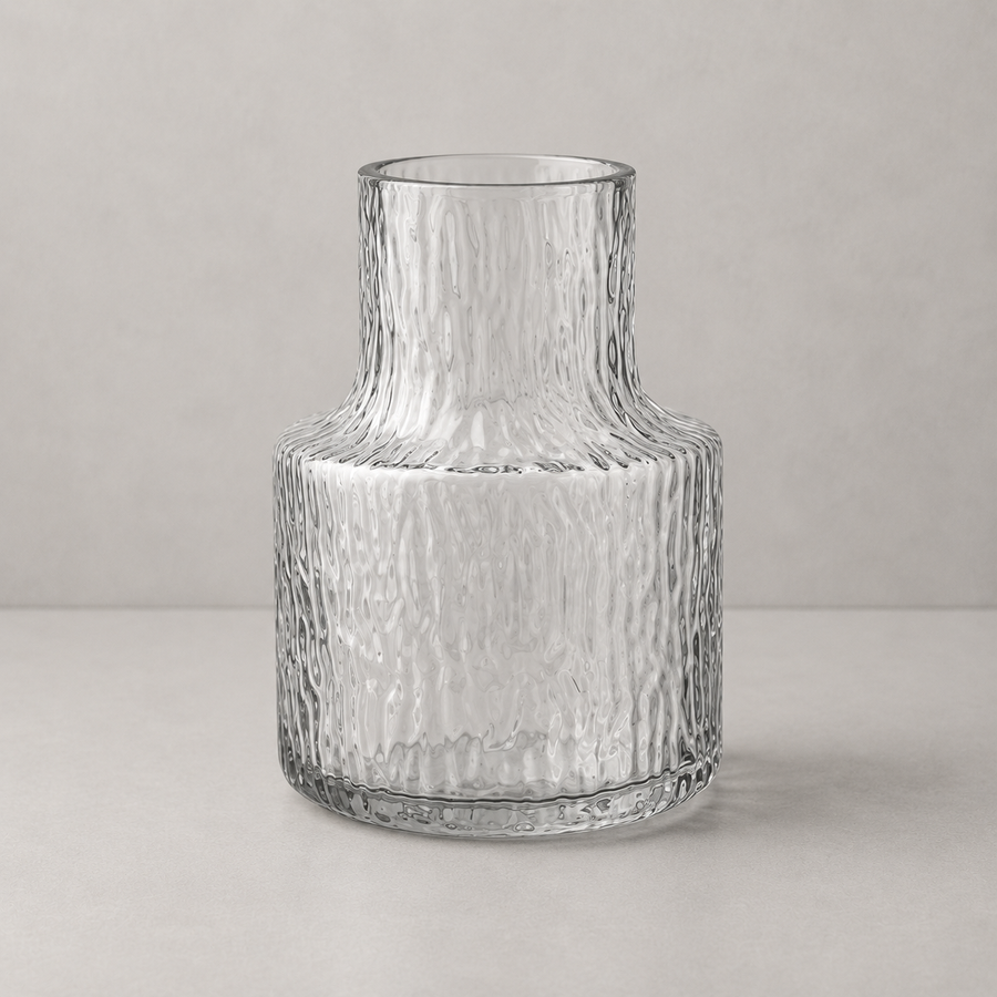 Clear glass vase with textured surface on a light gray background