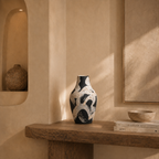 Decorative vase on a wooden shelf with a neutral background