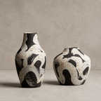 Two ceramic vases with black and white abstract patterns on a neutral background